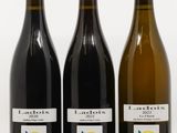 trois bouteilles de vin posées les unes à côté des autres sur une surface blanche