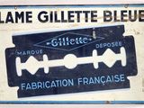 une affiche sur laquelle figure un rasoir et où l'on peut lire « Lame Gillette Blue »