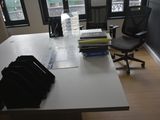 a desk with a chair and a laptop on it