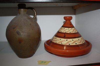 two vases sitting on a shelf next to each other