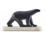 statue d'un ours noir posée sur un socle en marbre, sur fond blanc
