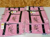 three bags of pink bags with black trims are on a table