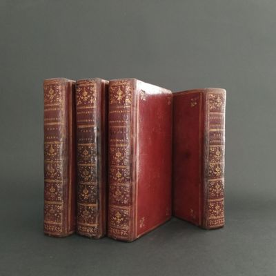 three red books are stacked on top of each other on a gray surface