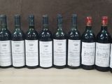 several bottles of wine are lined up in a row on a table