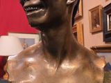 un buste en bronze représentant un homme souriant