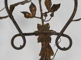 wrought iron wall sconce with leaves and flowers on it