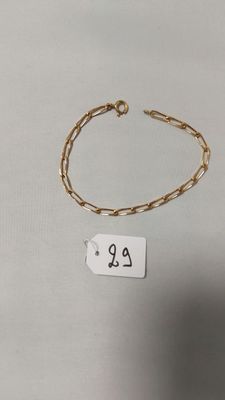Gros plan sur un bracelet en chaîne en or portant une étiquette
