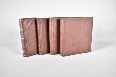 trois livres bruns posés l'un sur l'autre sur une surface blanche