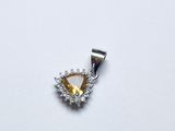 une image représentant un pendentif en forme de diamant jaune et blanc posé sur une surface blanche