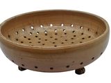 a wooden bowl with holes in it on a stand
