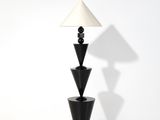 une image représentant une lampe noire surmontée d'un abat-jour blanc
