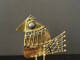 a bird made of wire and wood on a black surface