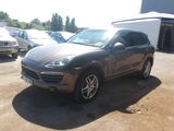 La Porsche Cayenne est garée sur un parking, avec d'autres voitures en arrière-plan.