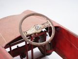 a red toy car with a steering wheel and a steering wheel