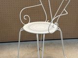 a white chair that is sitting in front of a wall