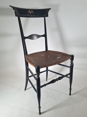 a black chair with a woven seat and a wooden seat