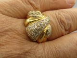 la main d'une femme tenant une bague en or sertie de diamants