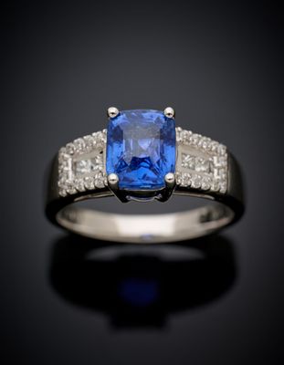 a blue sapphire and diamond ring on a black surface