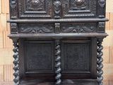 une vieille armoire en bois ornée de sculptures élaborées sur le dessus