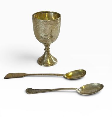 deux cuillères en argent et un gobelet en argent sur fond blanc