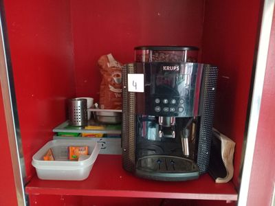 un meuble rouge sur lequel sont posés une cafetière et d'autres objets