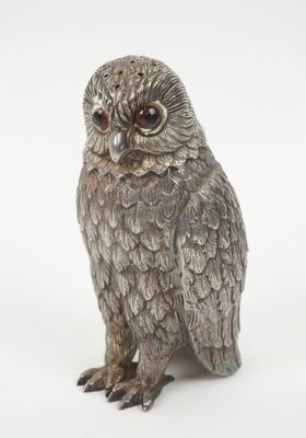 silver owl figurine on a white background