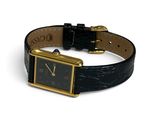an image of a black and gold watch on a black leather strap