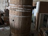 un grand tonneau en bois posé au milieu d'une pièce