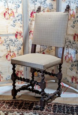 a chair that is sitting in front of a wallpapered wall