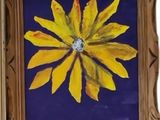 painting of a yellow flower in a wooden frame on a blue background