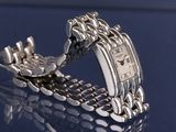 a silver watch sitting on top of a silver chain