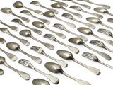 un grand nombre de cuillères et de fourchettes en argent disposées sur une table