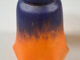 a blue and orange vase sitting on a white surface