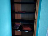 a book shelf in the corner of a blue room