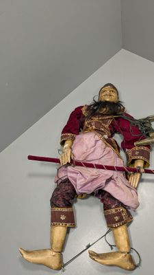 a statue of a man laying on the floor with a sword
