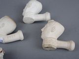 three white vases with handles and handles sitting on a gray surface