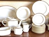 a lot of white dishes and cups on a table
