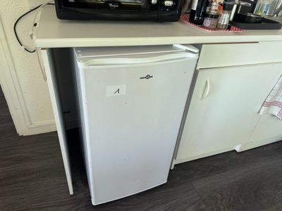 a small refrigerator in the corner of a small kitchen