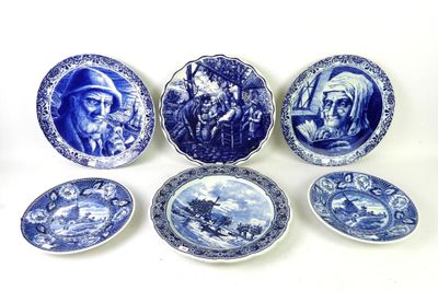 several blue and white plates with pictures of people and animals on them