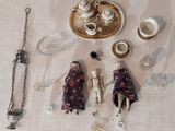 Des figurines sont disposées sur une table, accompagnées d'un plateau en argent et d'argenterie