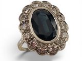 une image représentant une bague ornée d'une grosse pierre noire entourée de petits diamants blancs