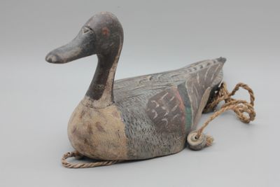 un vieux canard en bois avec une corde autour du cou