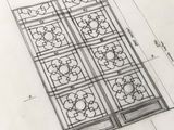 croquis d'un motif pour une fenêtre, avec un crayon posé dessus