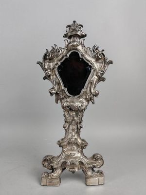 un miroir ancien plaqué argent, orné d'un verre noir au centre