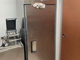 un réfrigérateur argenté dans une pièce dont la porte est marron