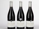 trois bouteilles de vin posées sur une table l'une à côté de l'autre