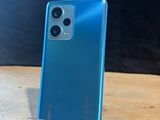 the back of a blue phone sitting on top of a wooden table