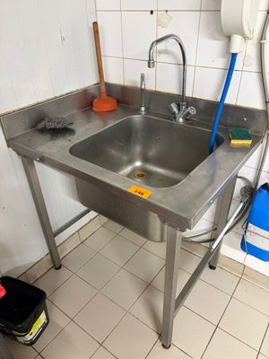 a stainless steel sink in the corner of a kitchen