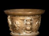 a bronze bowl with a design of a man and a woman