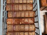 a basket full of old books sitting on a shelf